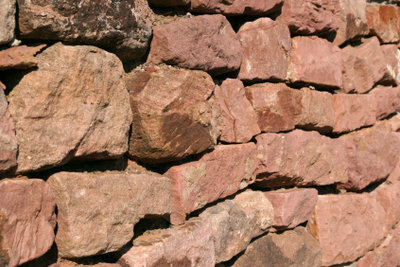 एक प्राकृतिक पत्थर की दीवार की लागत कम है।