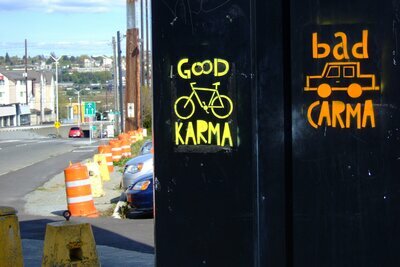 Graffiti that predicts good karma for cyclists and bad karma for drivers.