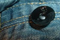 Fermez le bouton du jean avec la pince