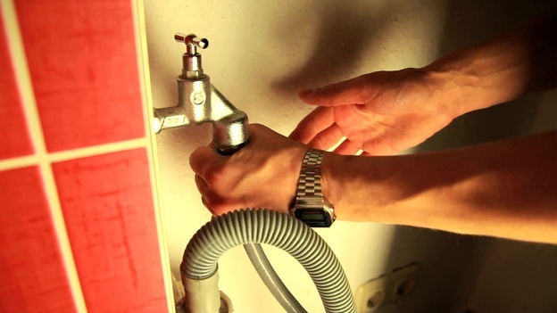 Turn the inlet hose to the tap by hand
